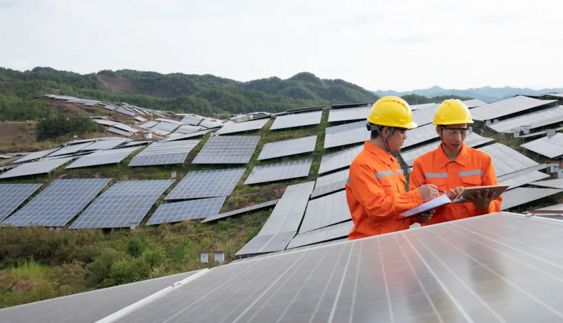 Two surveyors inspecting a solar wind farm