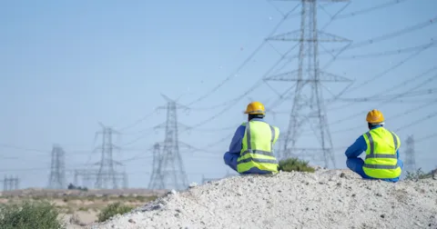 Two surveyors viewing power grids