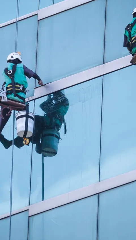 Group of workers cleaning windows service on high rise building
